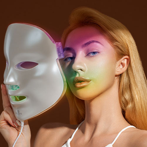 Model holds 7 color LED light therapy mask near her face 